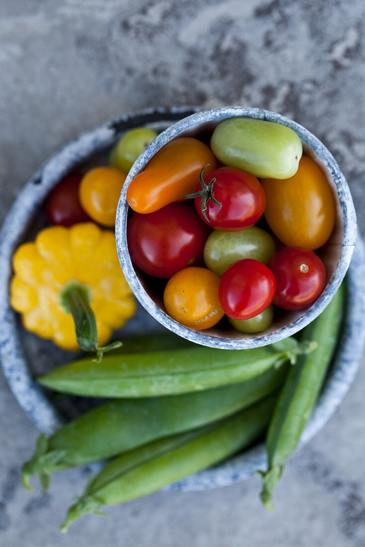 Various vegetables - colourful cherry tomatoes, snap peas, and yellow and green zucchini