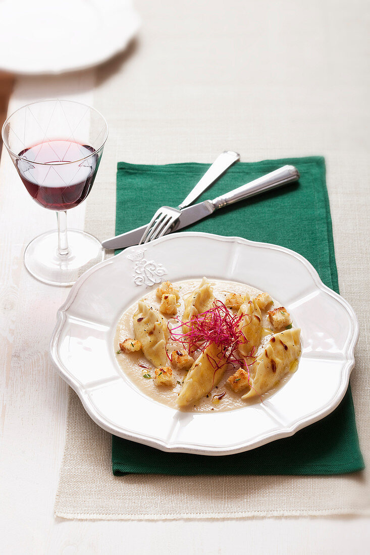 Nudeltäschchen mit Ricotta-Gorgonzola-Füllung auf cremiger Zwiebelsauce