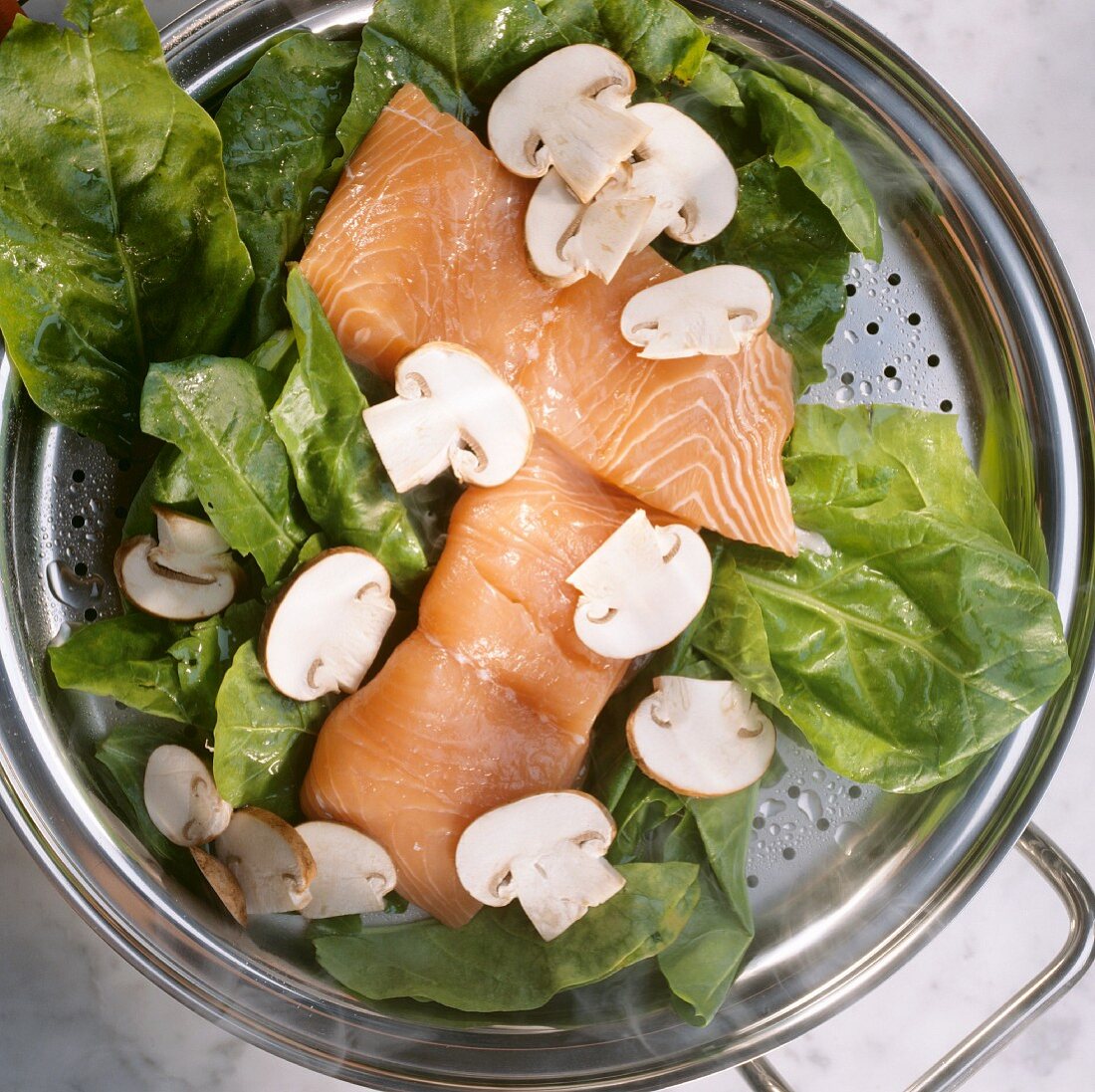 Steaming: salmon, spinach & mushrooms in steamer tray in pan