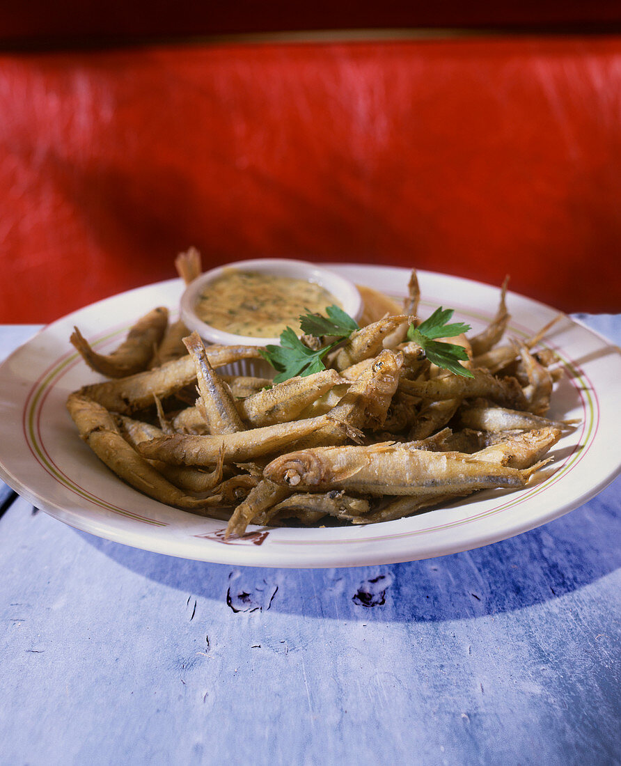 Deep fried fish with a dip on a plate