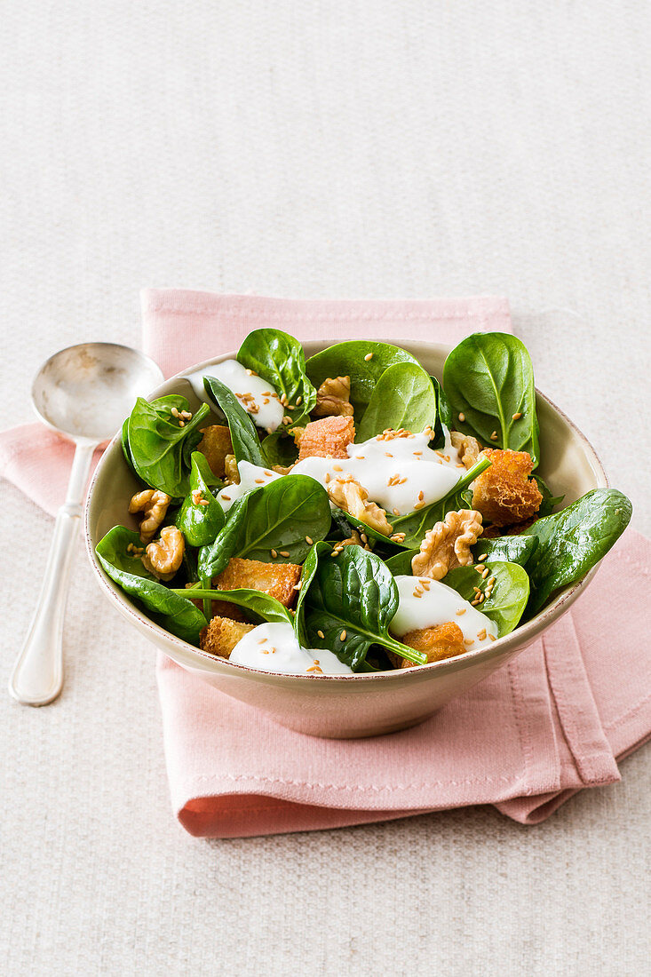 Babyspinatsalat mit Walnüssen, Sesam und Joghurt-Feta-Sauce