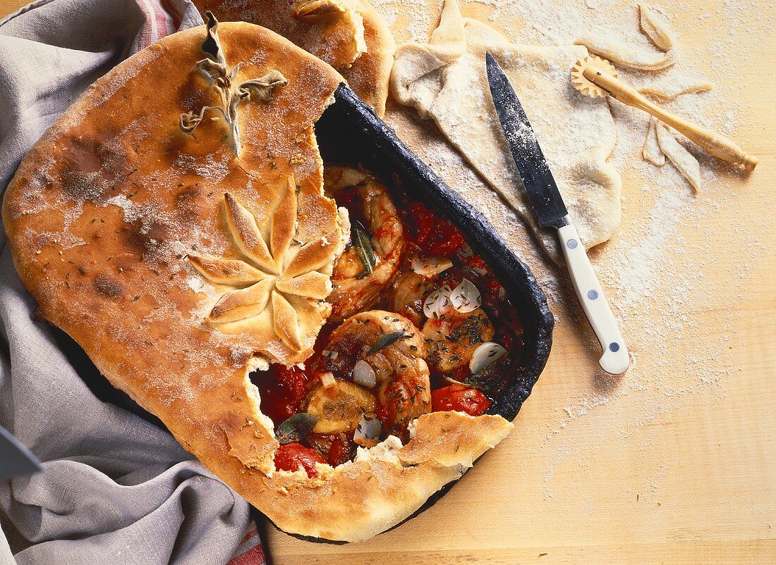 Ossobuco (shin of veal)in roasting tin with pizza dough topping