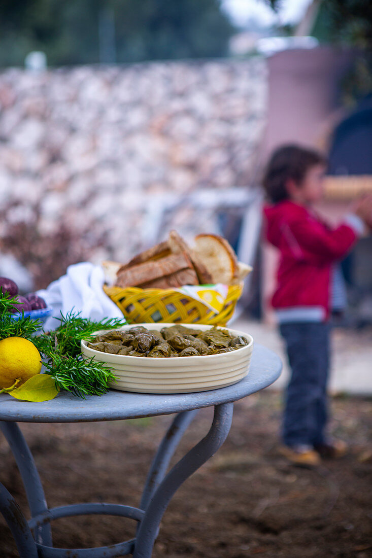 Dolmades, Ostereier und frisch gebackenes Brot auf Gartentisch