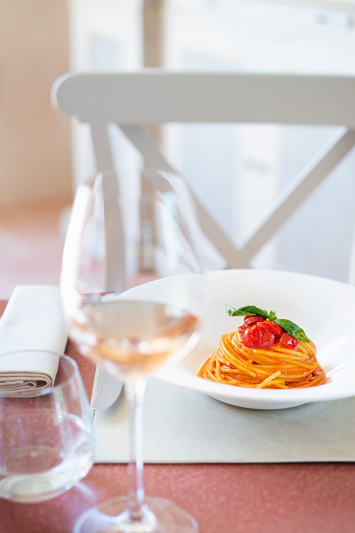 Restaurant table with a plate of spaghetti with tomato sauce
