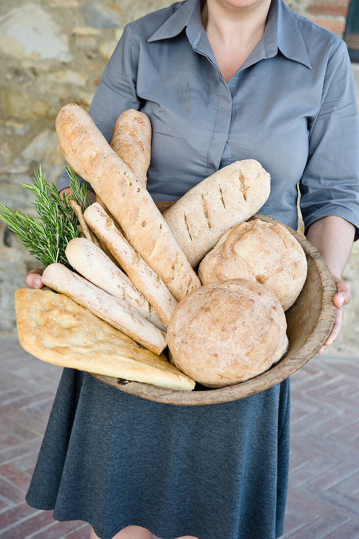 Frau hält Korb mit frisch gebackenen Broten