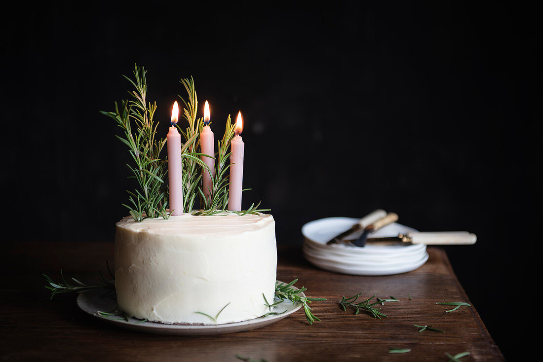 Lebkuchen-Schichttorte dekoriert mit Rosmarin und Kerzen