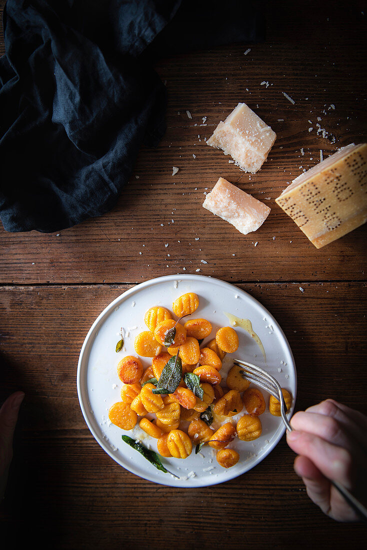 Kürbis-Gnocchi mit Salbei auf rustikalem Holztisch