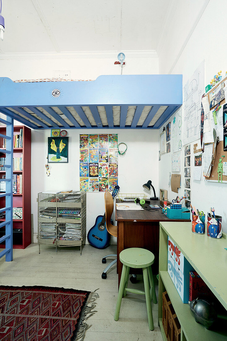 Jugendzimmer mit Schreibtisch unter blauem Hochbett