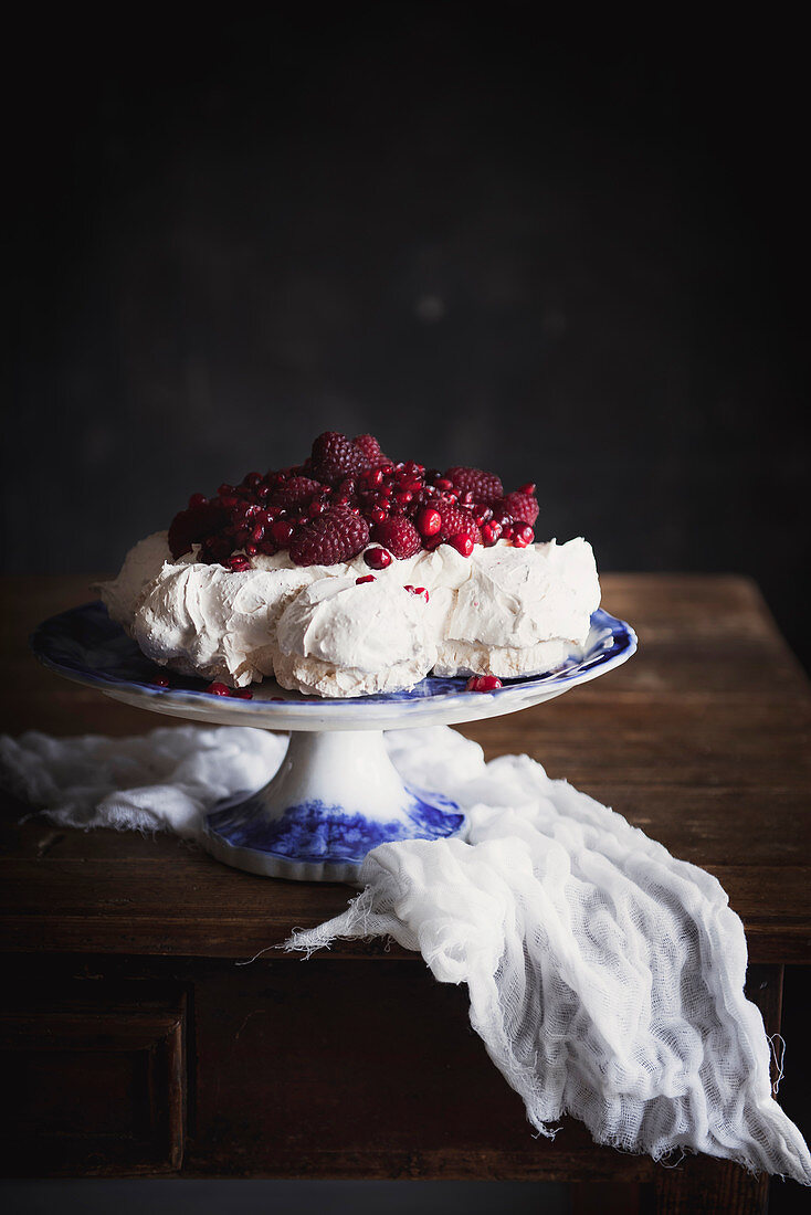 Pavlova mit roten Beeren auf Tortenständer