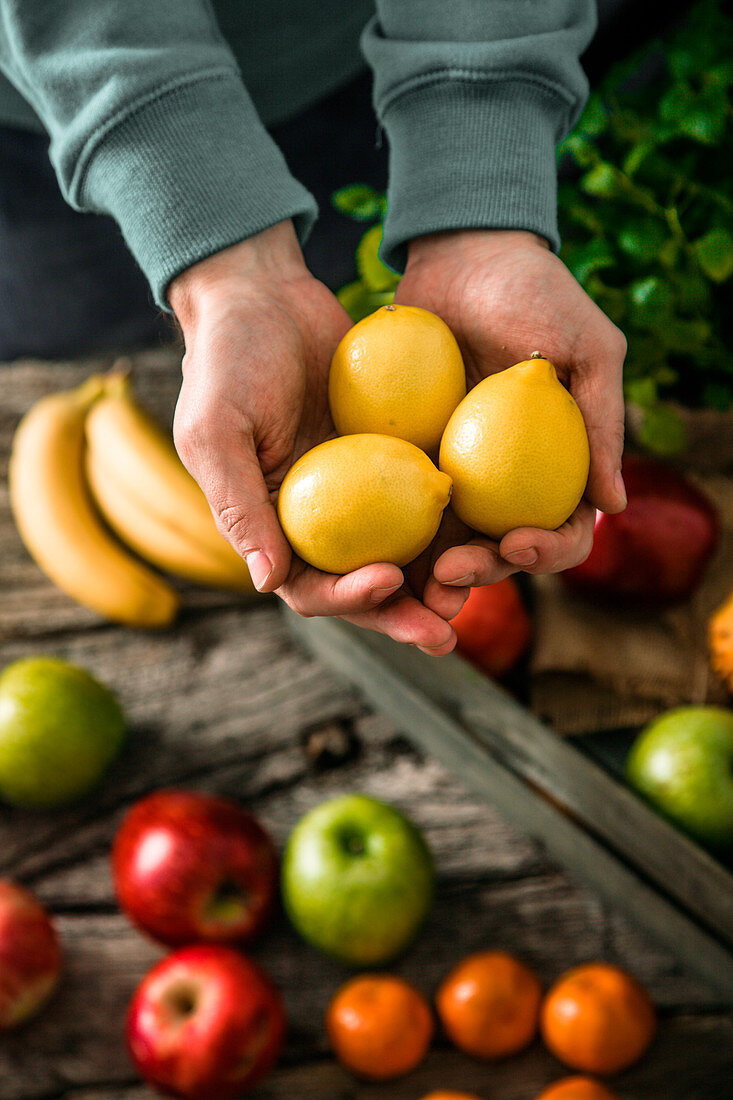 Hände halten drei Zitronen