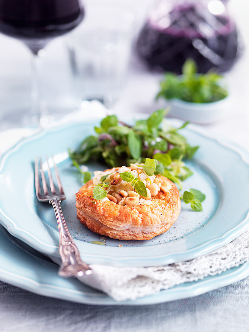 Spicy puff pastry topped with pine nuts, cheese and herbs