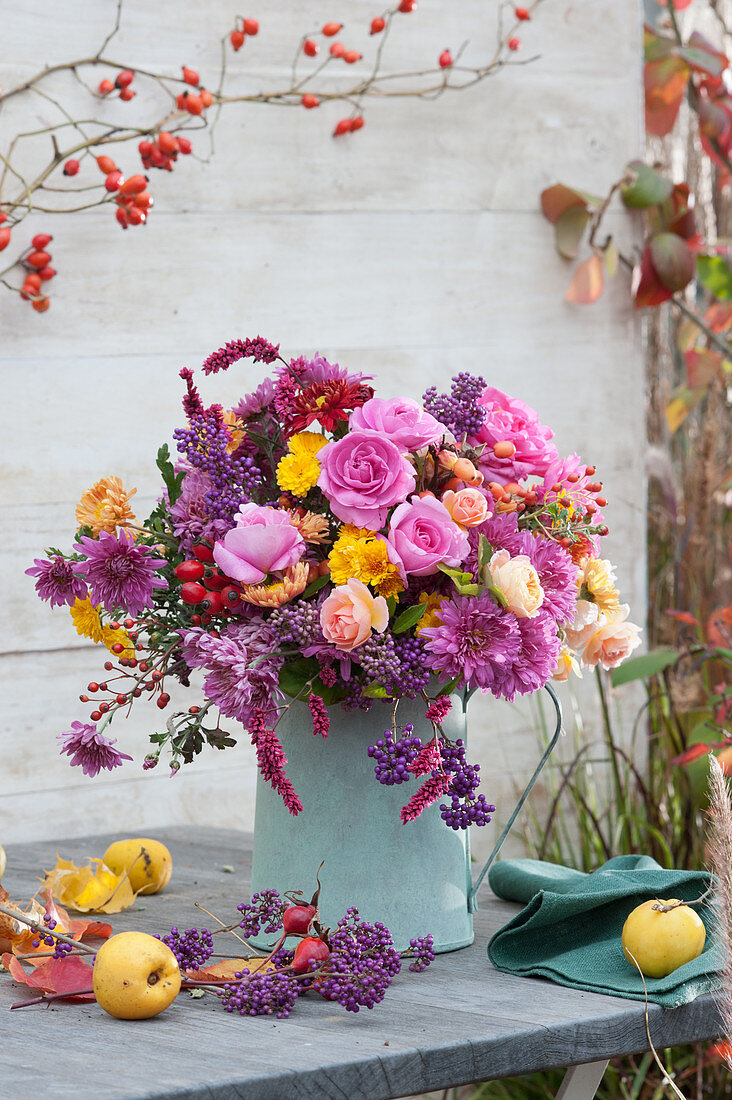 Autumn bouquet of roses, chrysanthemums, Callicarpa bodinieri, knotweed, and rose hips