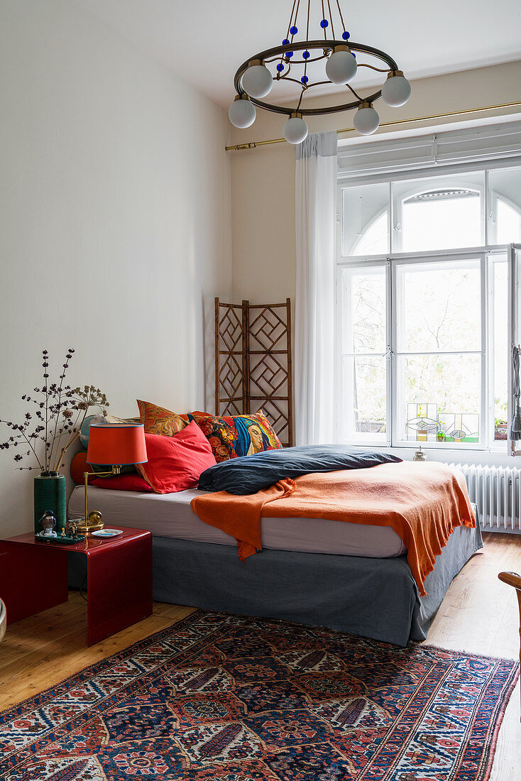 Doppelbett mit bunter Bettwäsche in Schlafzimmer