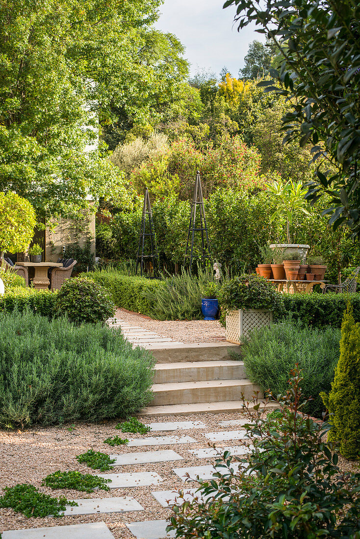 Garden path made from gravel and stone flags and steps in lushly planted garden