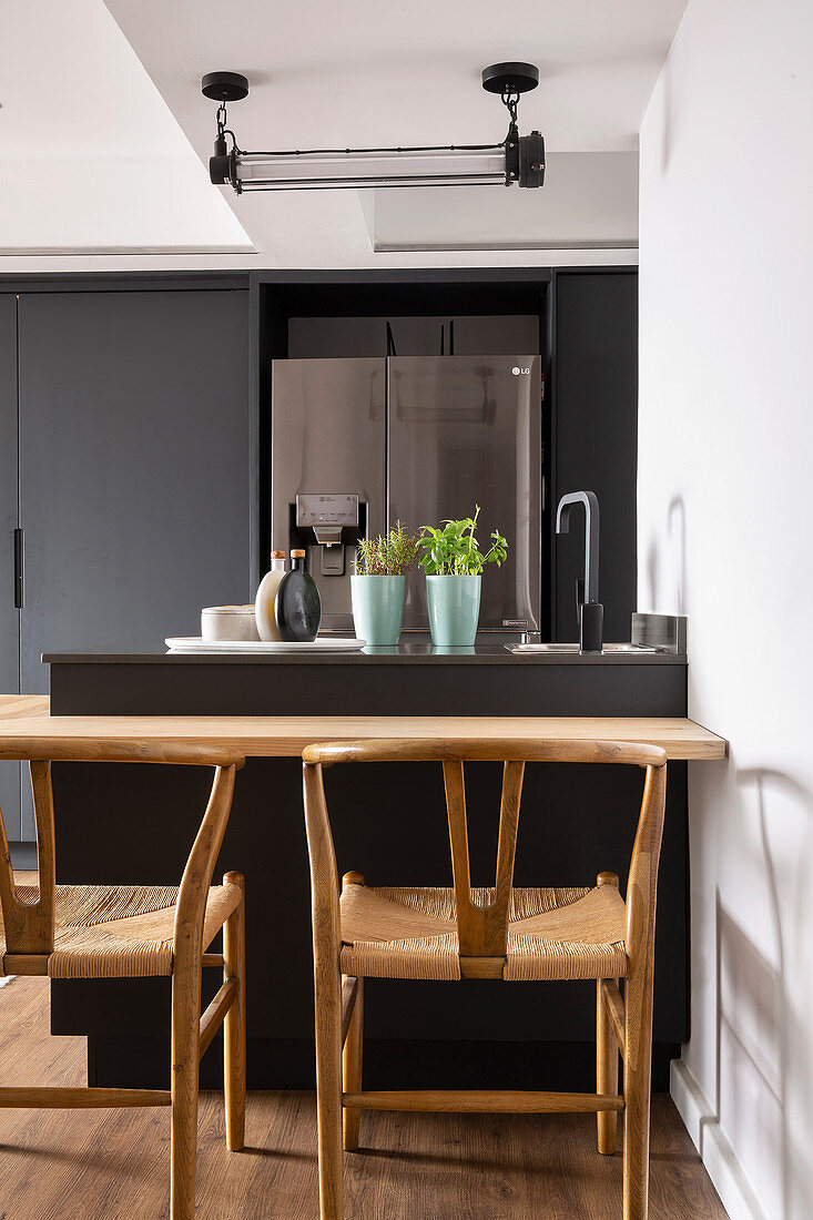 Small island counter with table top in charcoal-grey kitchen