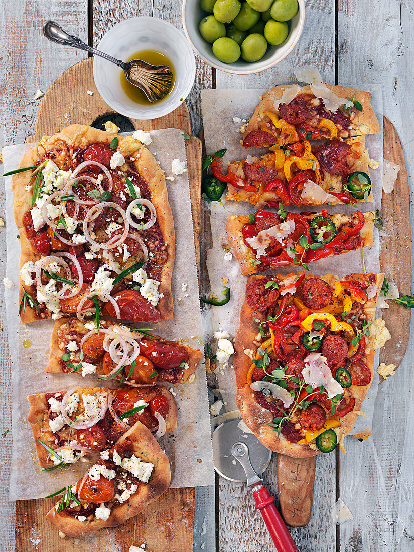Pizzazungen mit Oliven, Wurst, Paprika, Zwiebeln, Feta, Kräutern und Parmesan