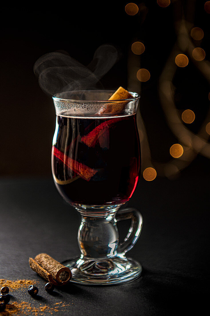 Glass of steming mulled wine with cinnamon