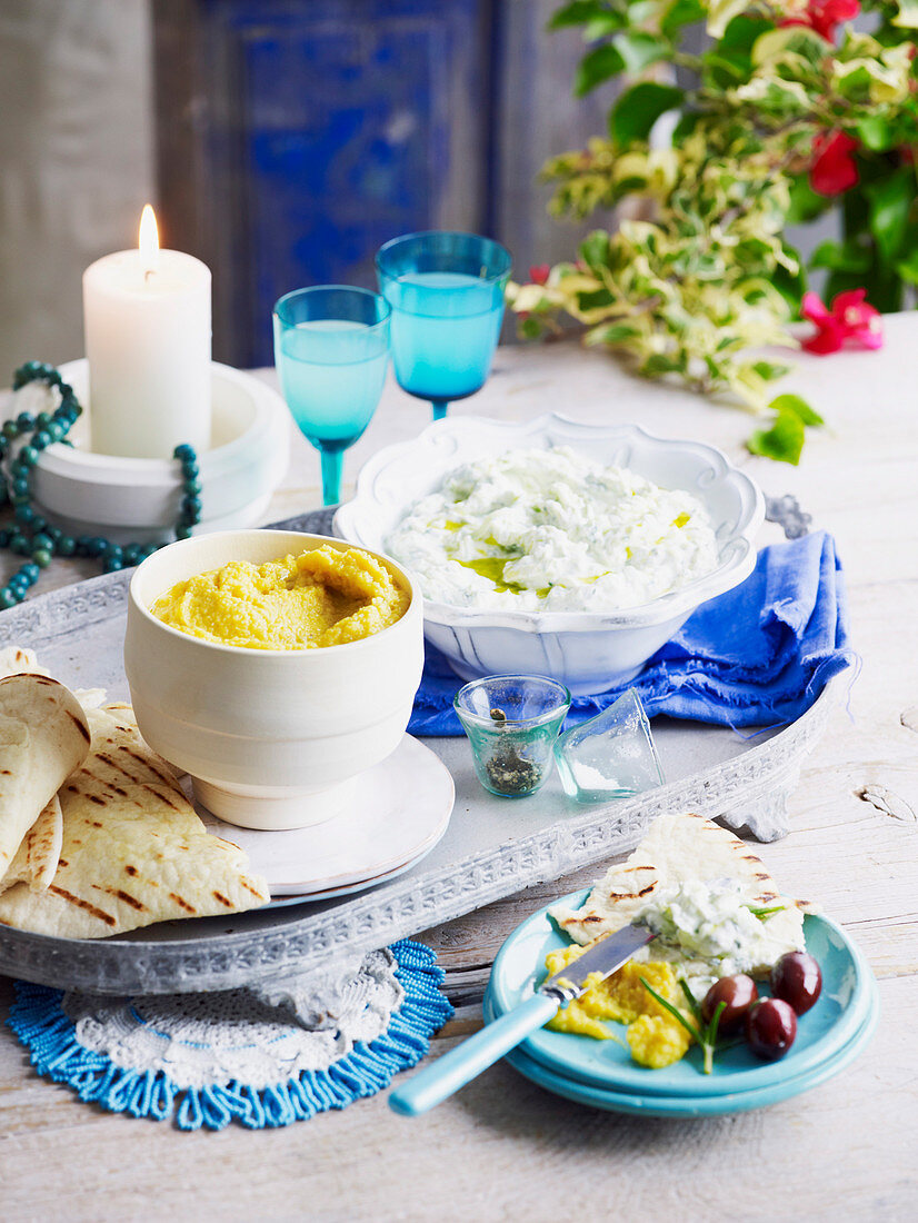 Tzatziki und Spalterbsen-Dip auf gedecktem Tisch (Griechenland)