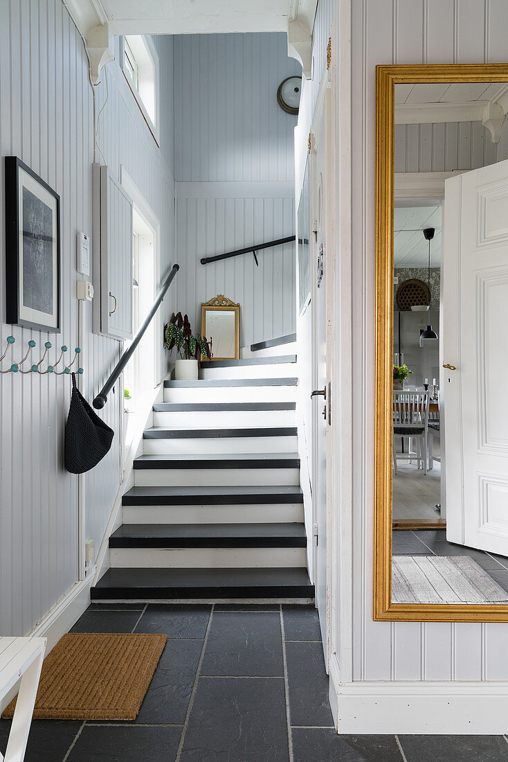 Staircase and mirror in foyer with grey panelled walls