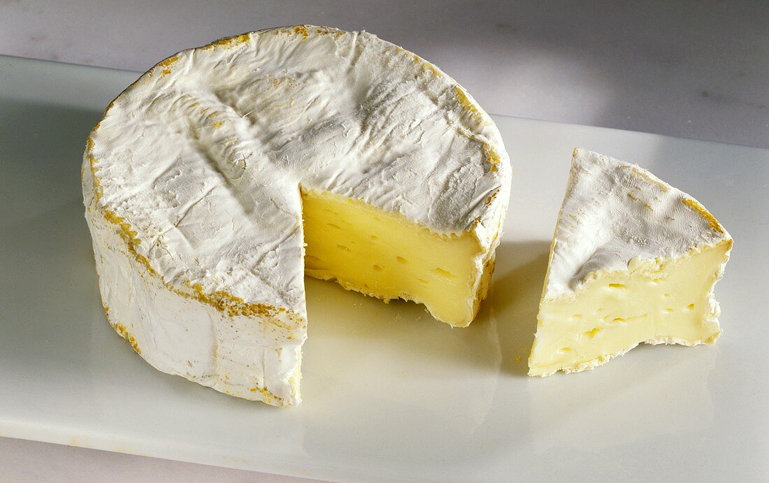 A Wheel of Camembert Cheese with a Wedge Cut Out