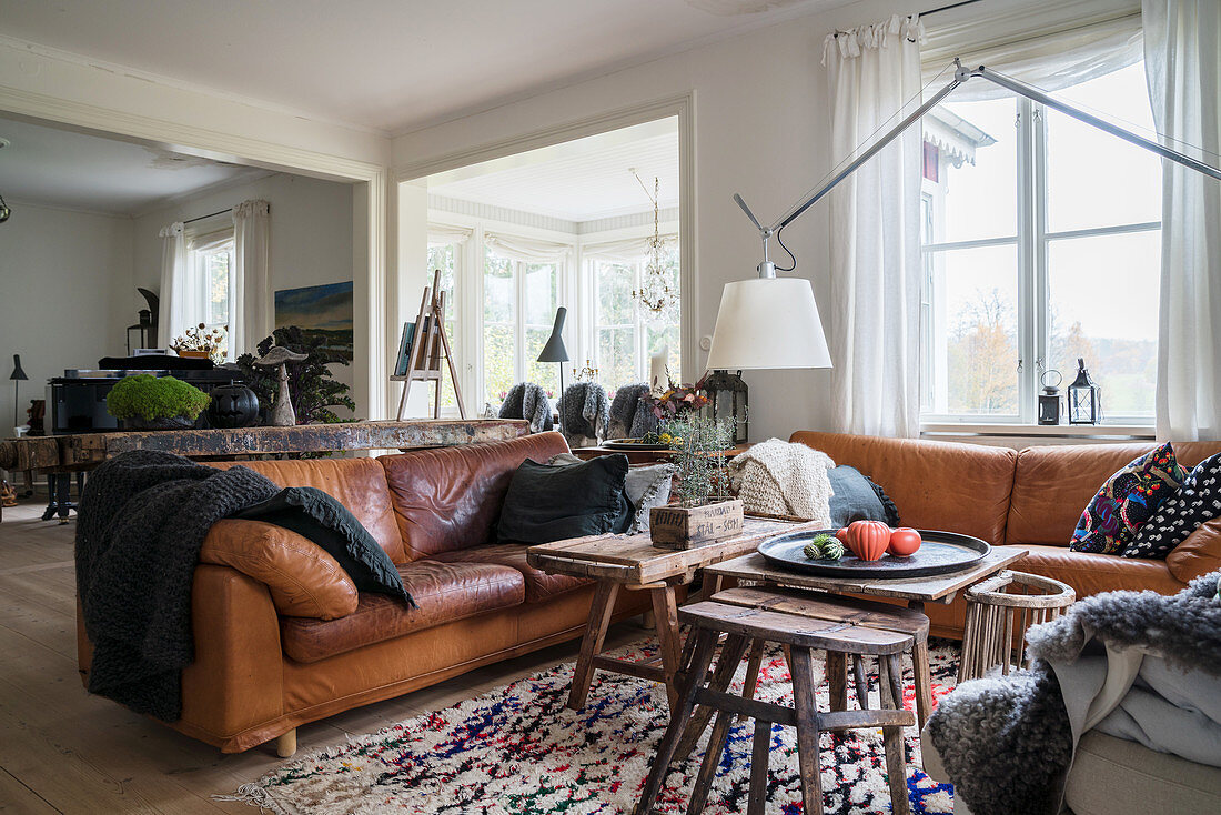 Cognac leather sofas and old stools used as coffee table