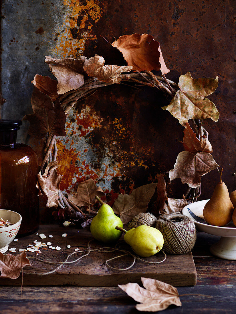 Birnen, Küchengarn und Kranz aus Herbstblättern