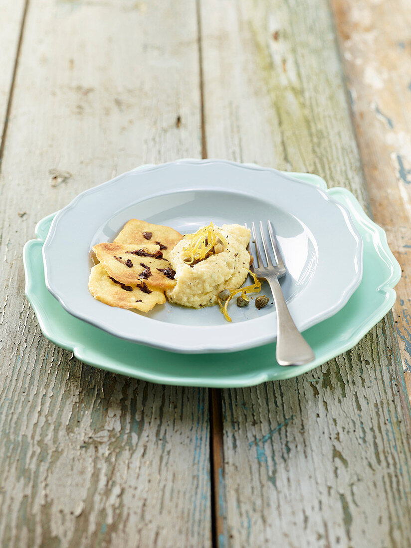 Flussbarschpüree mit Kartoffel-Oliven-Plätzchen, Kapern und kandierten Zitronenzesten