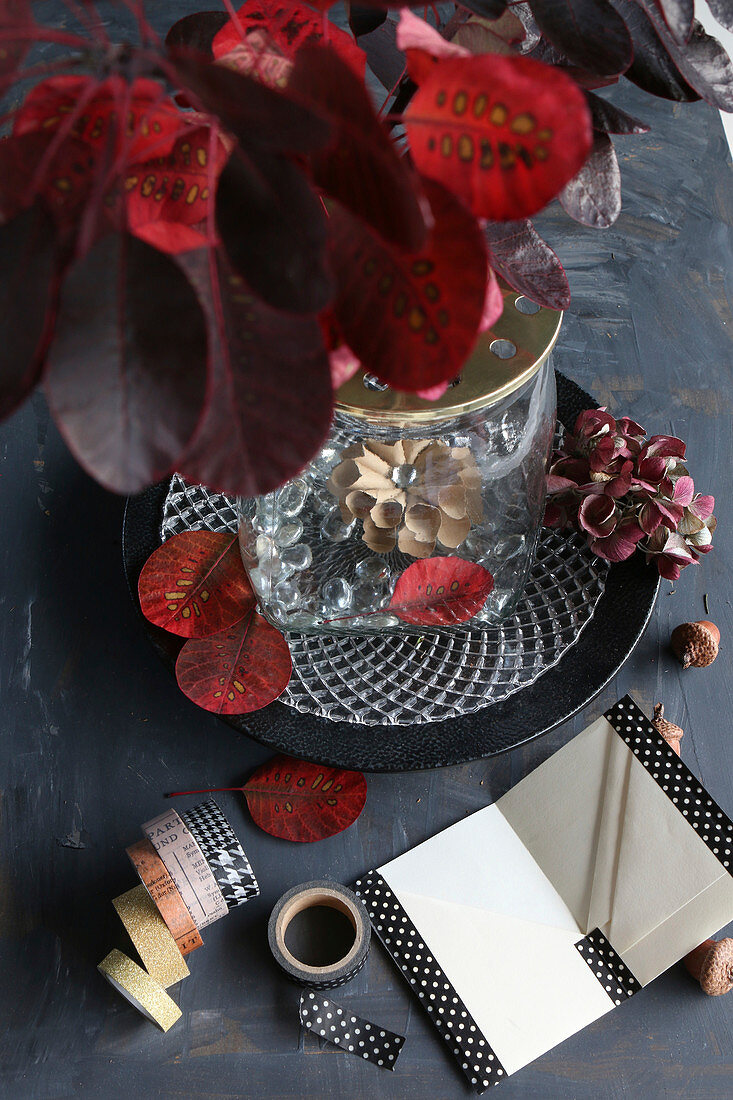 Handmade notebook bound with washi tape next to vase of leaves