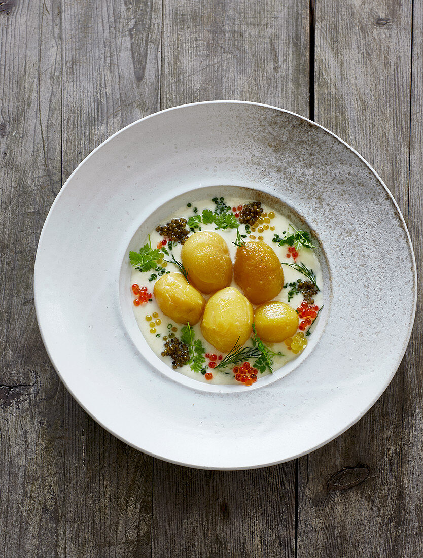 New potatoes with a white wine sauce, mixed herbs and colourful caviar