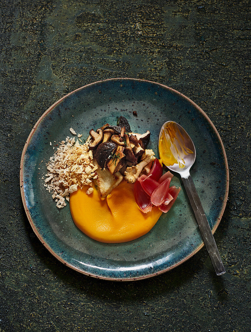 Pumpkin purée with fried mushrooms, grilled crumbs and pickled onions