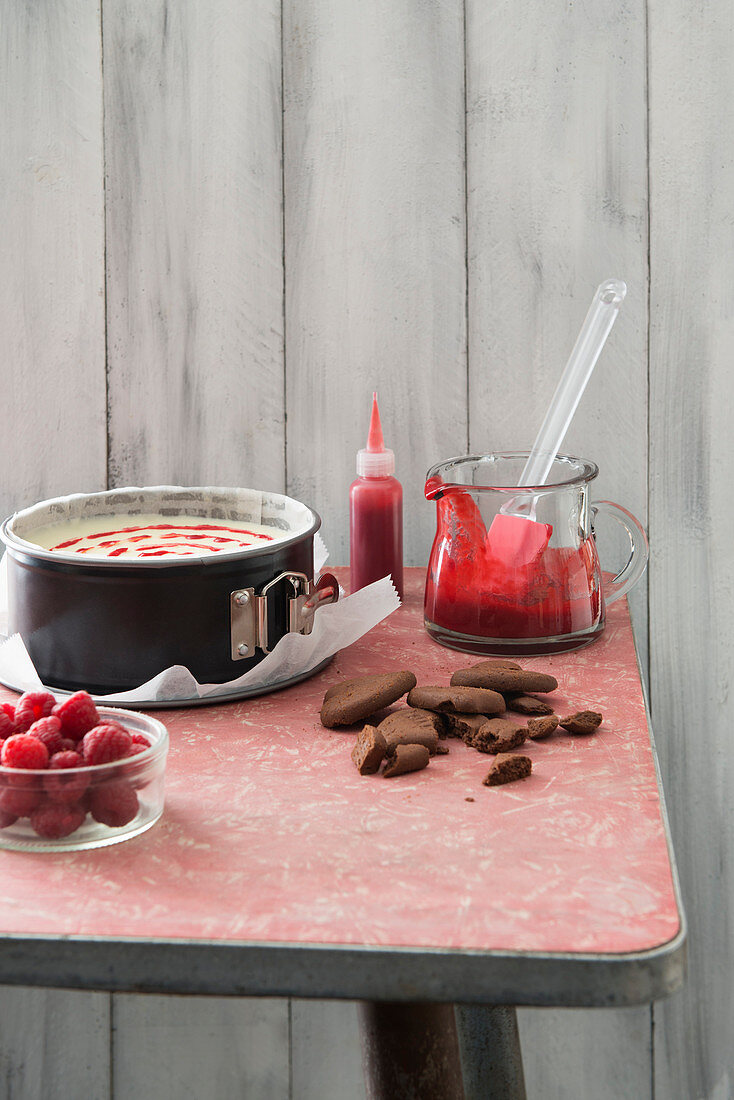 Cheesecake mit weisser Schokolade und Himbeeren und Backzutaten