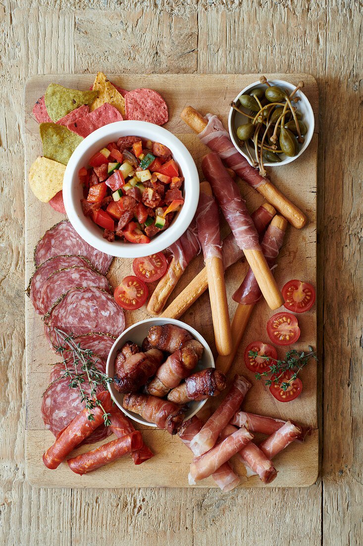 Wurstplatte mit Parmaschinken, Salami, Grissini, Tomaten und Riesenkapern