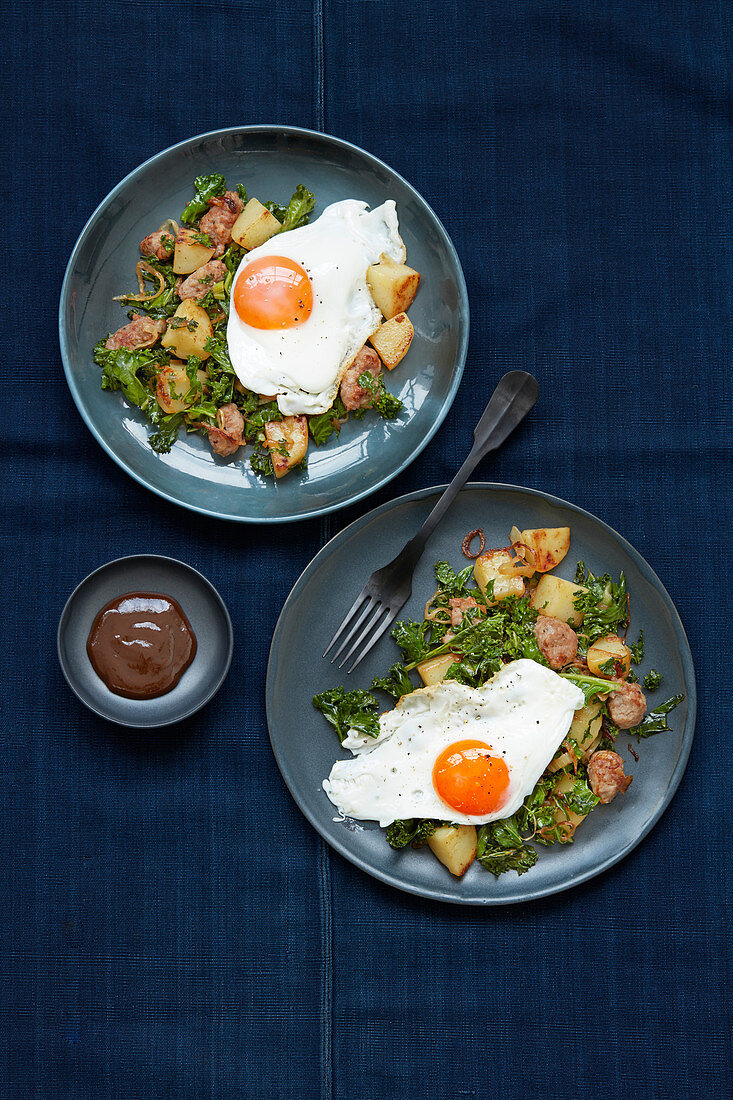 Hash Browns mit Kohl, Würstchen und Spiegeleiern