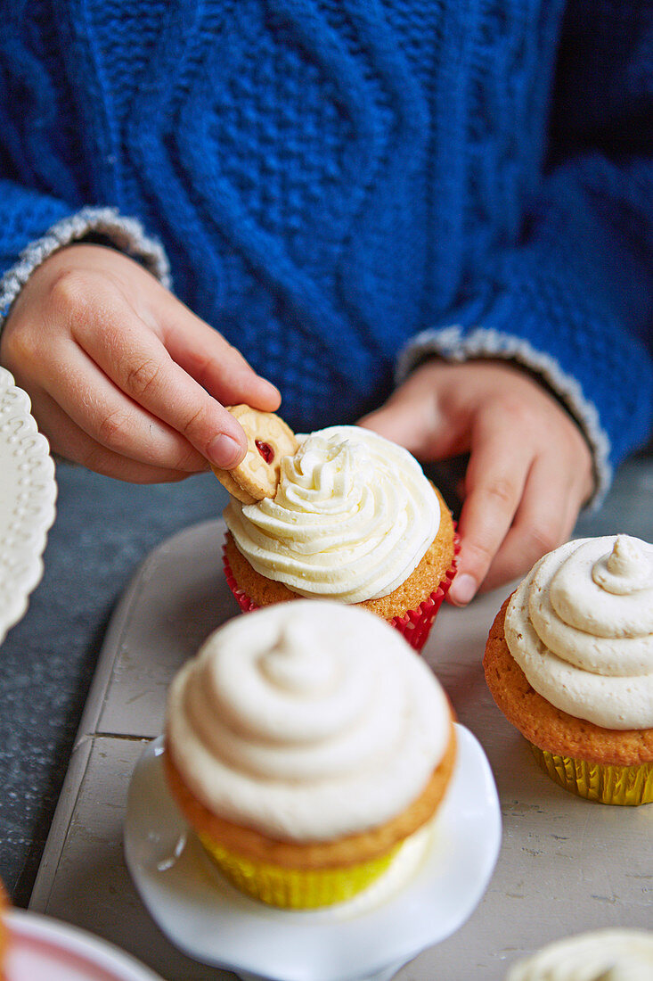 Kid eating ccokie with cupcakes