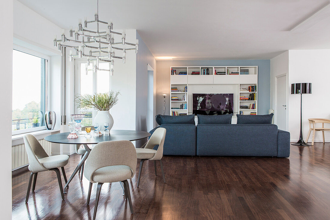 Interior divided into dining area by window and TV and lounge area in background