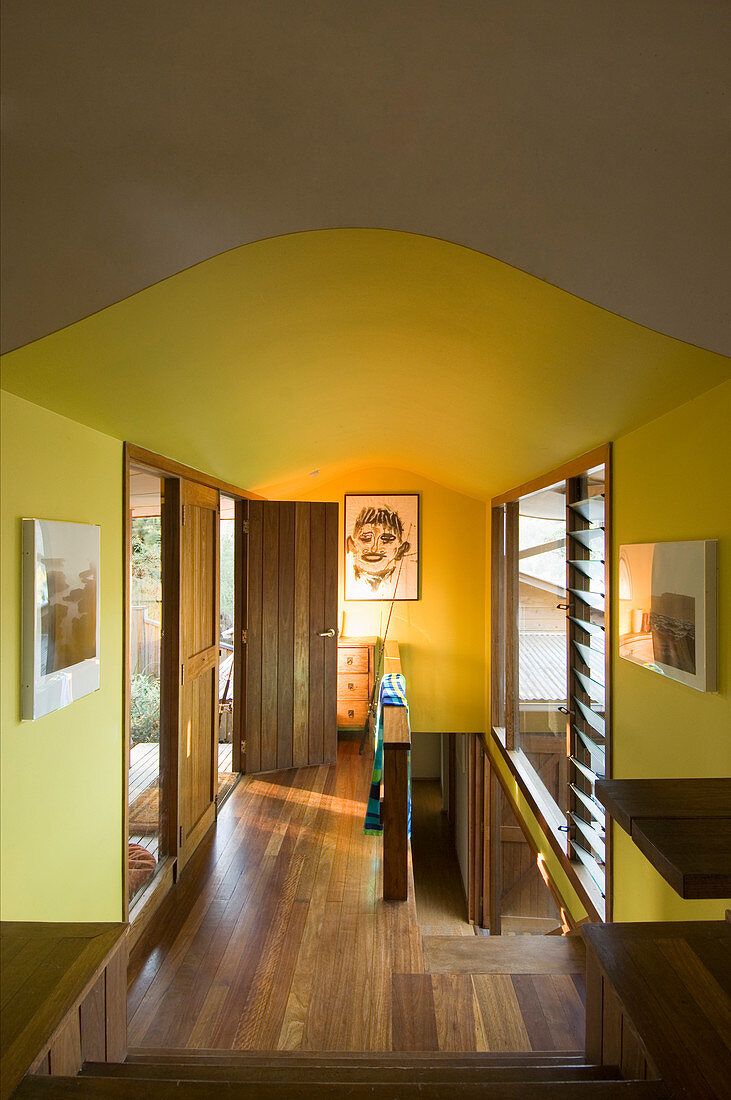 Yellow landing with oak doors, oak floor and stairs leading to lower floor