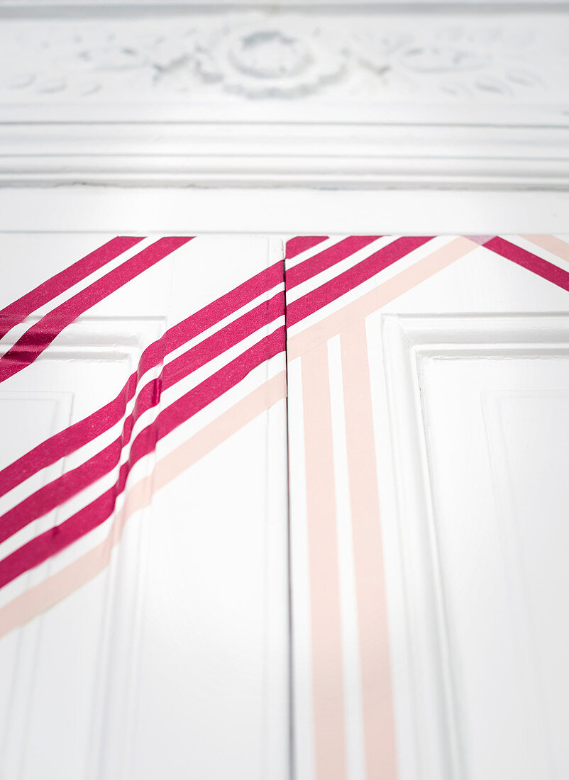 White panelled door decorated with hot-pink washi tape