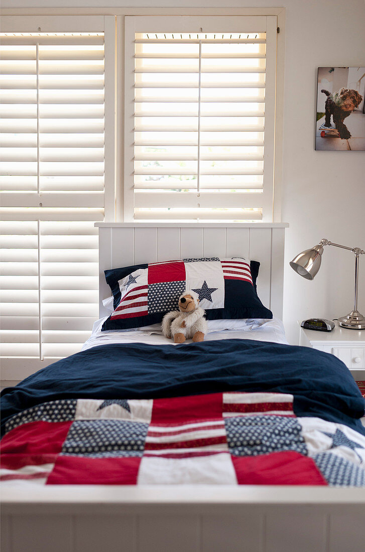 Bed linen with Stars-and-Stripes motif on bed in teenager's bedroom