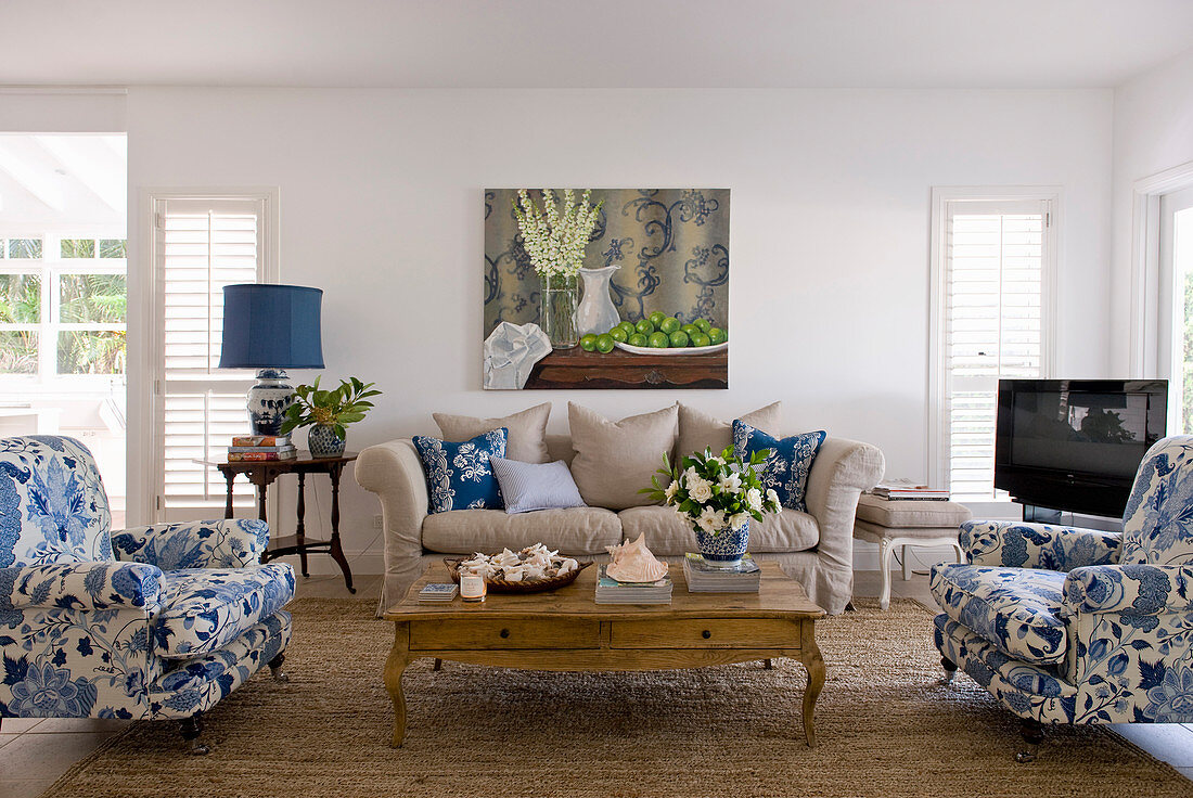 Upholstered furnishings in white, blue and ecru around coffee table in living room