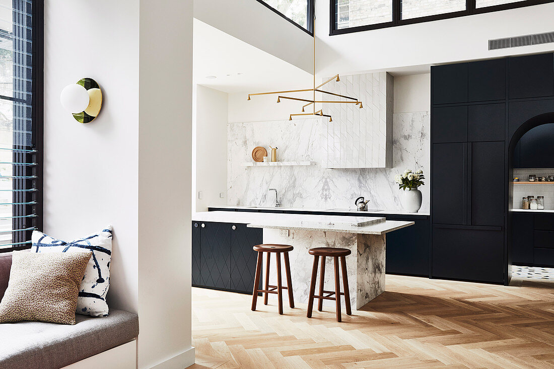 Open kitchen with black fittings and marble in a high living room