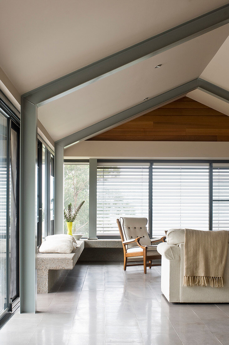 Simple living room below gable roof with exposed steel beams