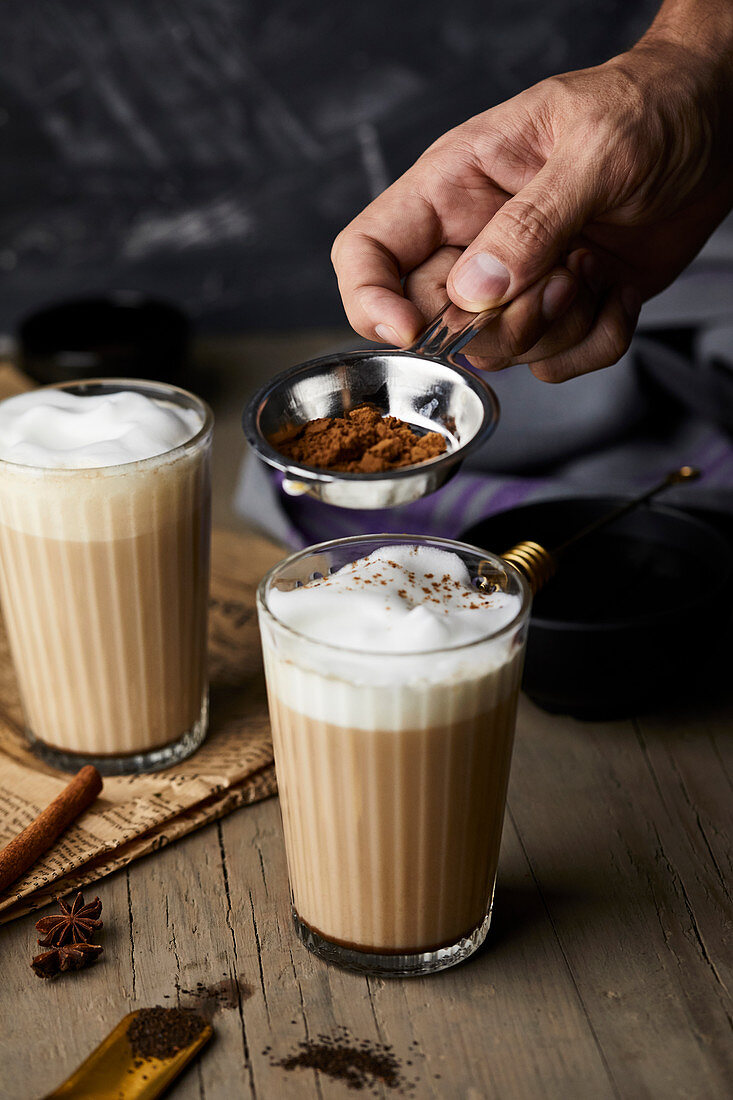 Chai Latte mit Zimtpulver bestäuben