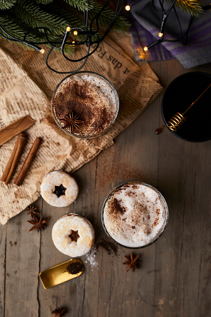 Chai latte in glasses with milk foam, cinnamon and anise stars