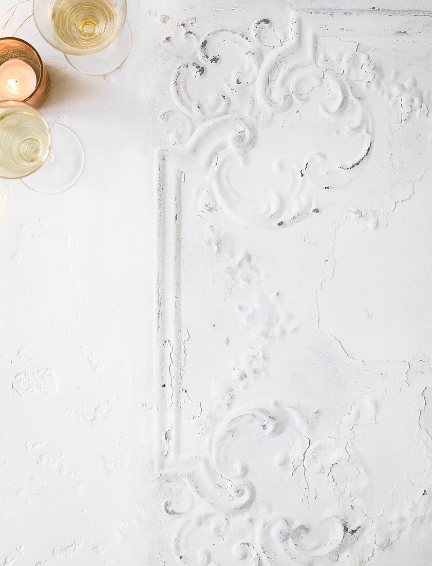 Tealight and wine glasses on a white background with ornamental decorations