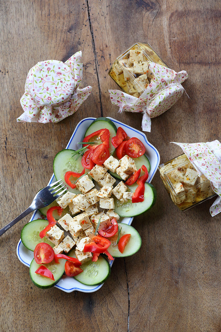 Preserved cream cheese in jars and on cucumber, tomatoes and peppers