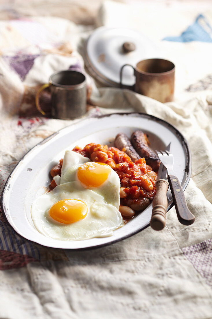Camping breakfast beans with sausages and fried eggs