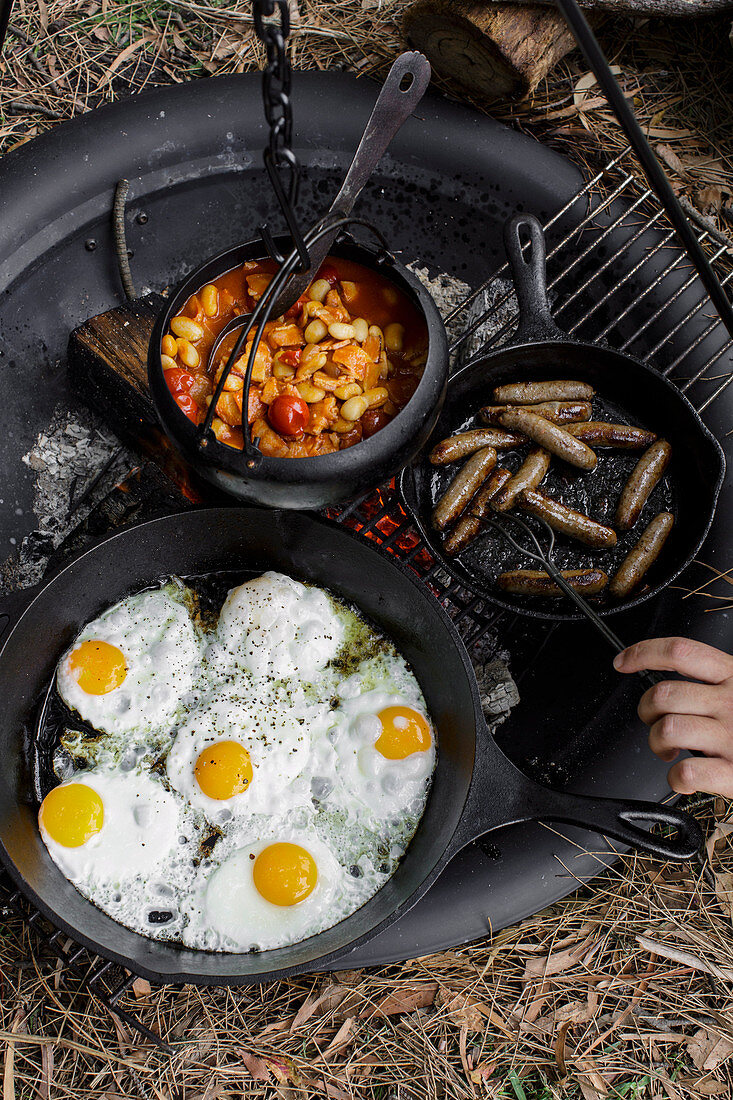 Camping breakfast beans with sausages and fried eggs