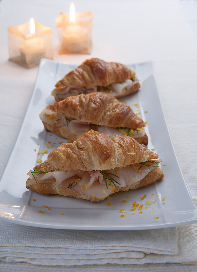 Croissants with smoked fish, orange zest and fennel leaves