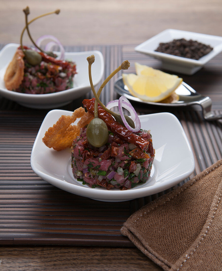 Tartare with capers, bread chips, onions and dried tomatoes