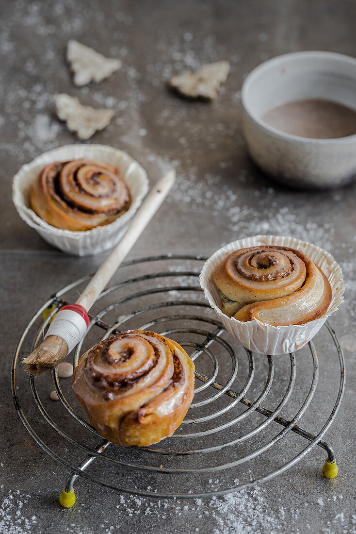 Cinnamon buns with icing on a wire rack